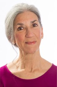 Elderly woman with gray hair, smiling gently.