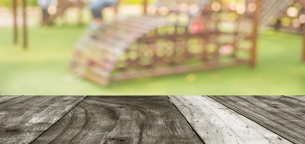 A wooden table with a blurry background of buildings.
